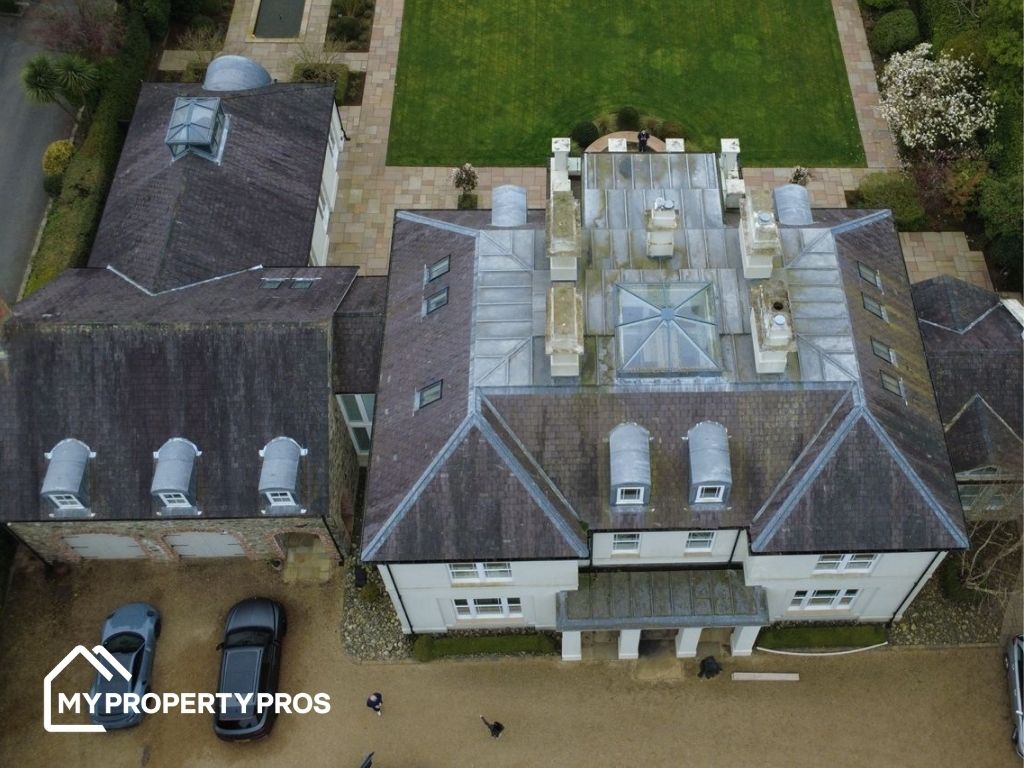 Aerial view of a roof before cleaning, showing moss and algae staining