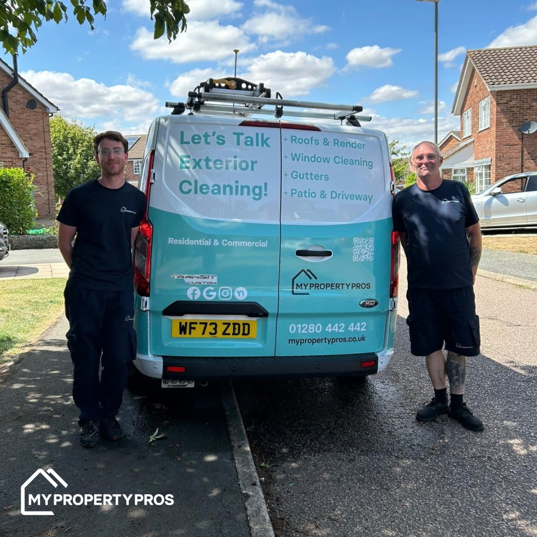 Two members of the Buckingham team standing either side of a My Property Pros van