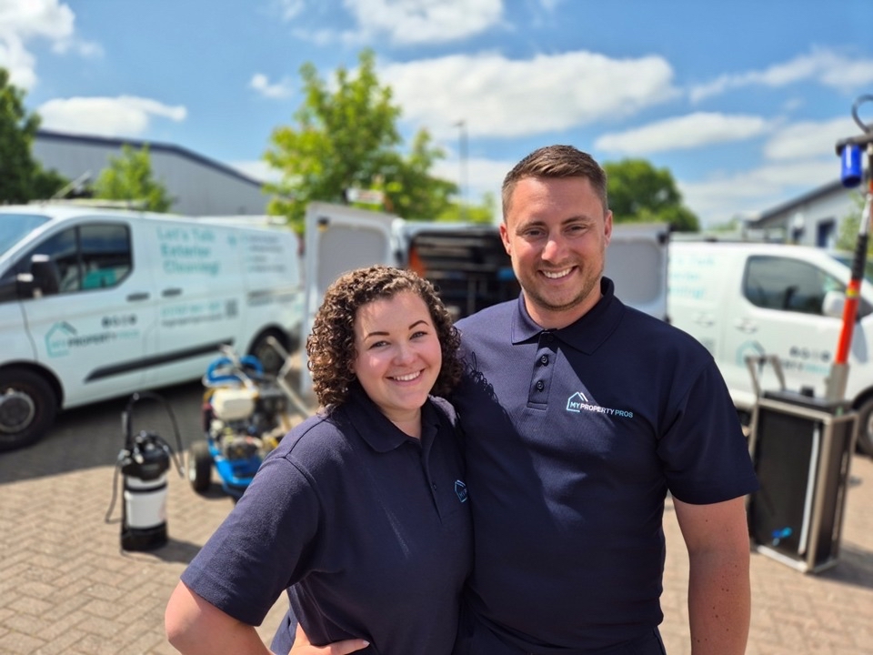 Will and Kerry Hayton standing together in front of their My Property Pros vans