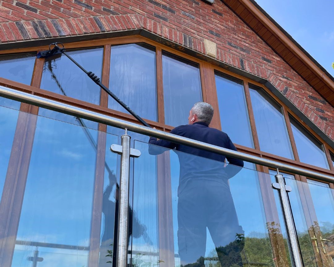 Liam Davis cleaning windows on a large residential property
